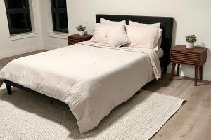 Un dormitorio con una cama grande con sábanas y almohadas blancas. en Modern 2 Bed Furnished Apartment in Quincy, en Quincy