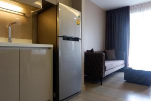 a kitchen with a refrigerator next to a couch at Residence 187 in Bangkok