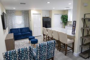 eine Küche und ein Wohnzimmer mit einem blauen Sofa in der Unterkunft Palm Beach Cottage in West Palm Beach