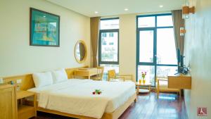a hotel room with a bed and a table and chairs at Gia Le Hotel in Tam Ðảo
