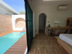 1 dormitorio con piscina, 1 cama y escritorio en Dara Homestay, en Ko Kood