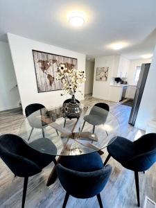a living room with a glass table and chairs at Walking distance to St Boniface, easy parking in Winnipeg