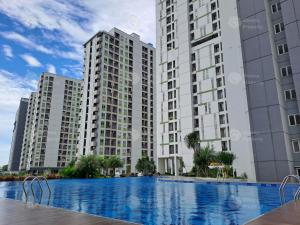 a view of two tall buildings and a swimming pool at Sheena Property At Akasa Pure Living in Ciater-hilir