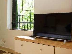 a flat screen tv sitting on top of a dresser at Hoàng Lan - 22 Liền Kề 13, KDT Xa La - by Bay Hostel in Hanoi