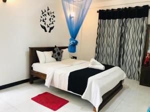 1 dormitorio con cama y cortina azul en Mihisara Resort en Anuradhapura