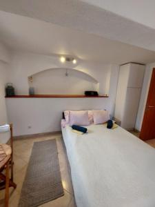 1 dormitorio con 1 cama blanca grande y 2 almohadas en Apartments Jagoda - next to the sea, en Donje Selo na Šolti