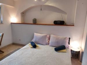 1 dormitorio con 1 cama con 2 almohadas y cámara en Apartments Jagoda - next to the sea, en Donje Selo na Šolti