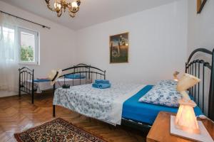 1 dormitorio con 2 camas y mesa en Apartment Florio - garden & free parking, en Trogir
