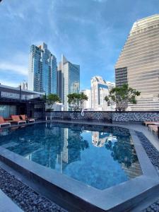 uma piscina com um horizonte urbano ao fundo em Ramada by Wyndham Bangkok Sukhumvit 11 em Bangkok