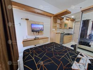 a bedroom with a bed and a television on the wall at Sheena Property At Akasa Pure Living in Ciater-hilir