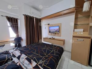 a bedroom with a bed and a desk and a tv at Sheena Property At Akasa Pure Living in Ciater-hilir
