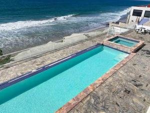 two swimming pools with the ocean in the background at Hermoso Departamento frente al Mar in Tijuana