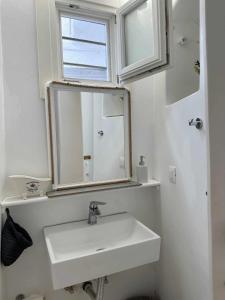 a white bathroom with a sink and a mirror at Terra Nova in Mikonos