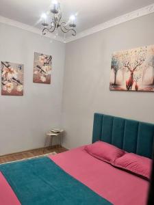 Schlafzimmer mit einem Bett und Wandmalereien in der Unterkunft 2-х комнатная в Золотом квадрате in Almaty + 14 Fotos