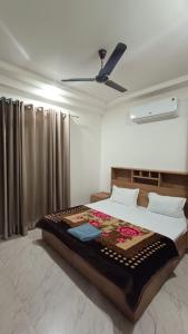 a bedroom with a bed and a ceiling fan at 85 The Ganges 2 BHK Apartment for Homestay in Rishīkesh