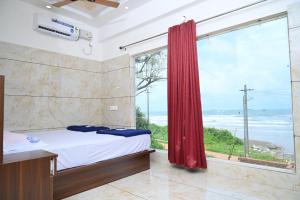 um quarto com uma cama e uma grande janela em Blue Pearl Beach Guest House em Māvalli