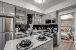 a kitchen with stainless steel appliances and a living room at Cozy Nest in Niagara Falls