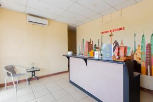 a waiting room with a counter and a chair at RedDoorz @ Iodium Residence Cikarang in Jakarta