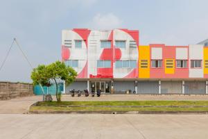 a colorful building with people sitting on benches in front of it at RedDoorz @ Iodium Residence Cikarang in Jakarta