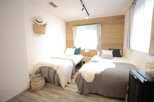 sypialnia z 2 łóżkami i oknem w obiekcie SAUNAFORESTCABIN軽井沢御代田zenasobi棟 w mieście Oiwake