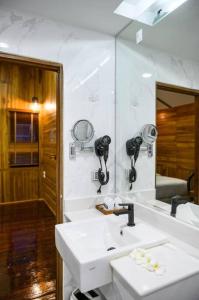 een badkamer met een witte wastafel en een spiegel bij U Villa Chiangkhan (อยู่วิลล่าเชียงคาน) in Chiang Khan
