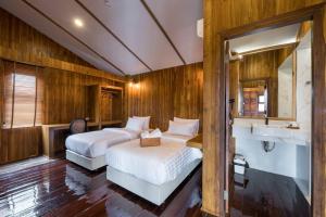 een slaapkamer met 2 bedden en een wastafel bij U Villa Chiangkhan (อยู่วิลล่าเชียงคาน) in Chiang Khan