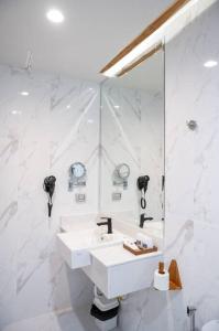 a white bathroom with a sink and a mirror at U Villa Chiangkhan (อยู่วิลล่าเชียงคาน) in Chiang Khan