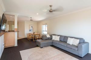 a living room with a couch and a table at Breakers 1 8 LJHooker Yamba in Yamba