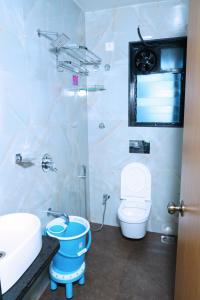 Baño blanco con aseo y lavamanos en hotel suraj classic, en Pune
