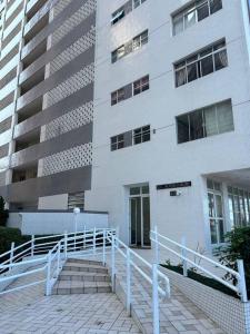 a white building with stairs in front of it at Beautiful condo by the shore in Santos