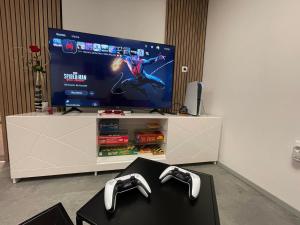 a television with two video game controllers in a living room at Apartma Devs in Kranjska Gora