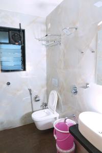 a white bathroom with a toilet and a sink at hotel suraj classic in Pune