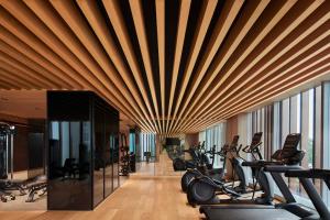 a gym with a wooden ceiling and rows of exercise bikes at Taj The Trees, Mumbai in Mumbai