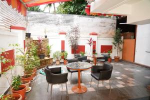 a patio with a table and chairs and plants at hotel suraj classic in Pune