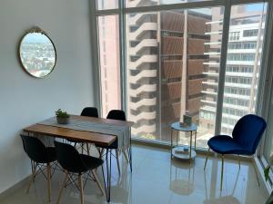 a dining room with a table and chairs and a large window at Hermoso Departamento frente al Mar in Tijuana