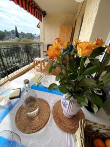 une table avec un vase de fleurs sur une table dans l'établissement Logement cosy, situé entre ciel et mer, à Vence