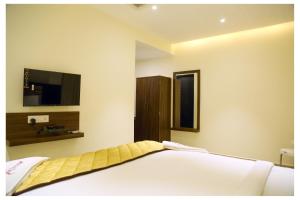a bedroom with a bed and a flat screen tv at Starwin Residency in Rāmanāthapuram