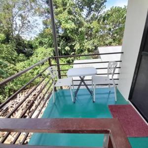 a balcony with a bench and a table on a porch at Palawan-Residence B&B in Puerto Princesa City