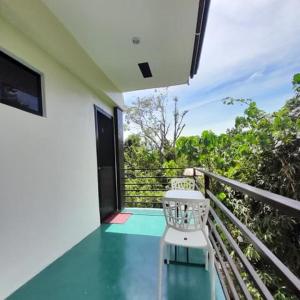 a balcony with a table and a chair on a porch at Palawan-Residence B&B in Puerto Princesa City