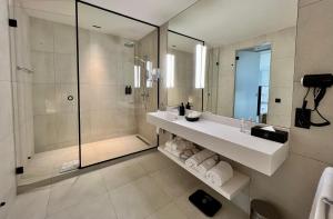 a bathroom with a shower and a sink and a mirror at OPO Hotel in Brussels