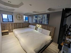 a large bed in a room with a clock on the wall at 亞馨文旅 YesHome Hotel in Hualien City
