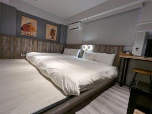 a bedroom with a large white bed in it at 亞馨文旅 YesHome Hotel in Hualien City