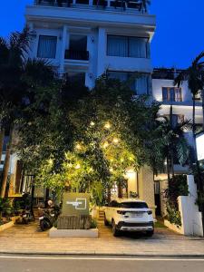 um carro branco estacionado em frente a um edifício em Homewood Hotel By Seuya Hotel em Siem Reap