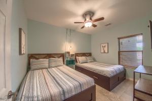 Un dormitorio con dos camas y un ventilador de techo. en RG 105 Rio Refuge, en Canyon Lake 15 fotos más