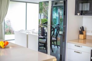 a kitchen with a white counter and a dining room at Phuket Boutique Pool Villa-81 in Rawai Beach