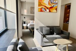 a living room with a couch and a chair and a bed at OPO Hotel in Brussels