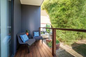 2 chaises assises sur une terrasse couverte avec balcon dans l'établissement Cozy 1 Bed 1 Bath Tiny Home near CBD, à Brisbane