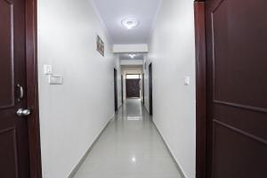 een hal met witte muren en een donkerbruine deur bij OYO New Airport Residency in Jaipur