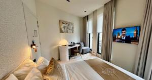 ein Hotelzimmer mit einem Bett und einem TV in der Unterkunft OPO Hotel in Brüssel