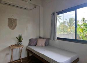 a room with a bench with a window and a table at Pacifico Surf Bayay in San Isidro